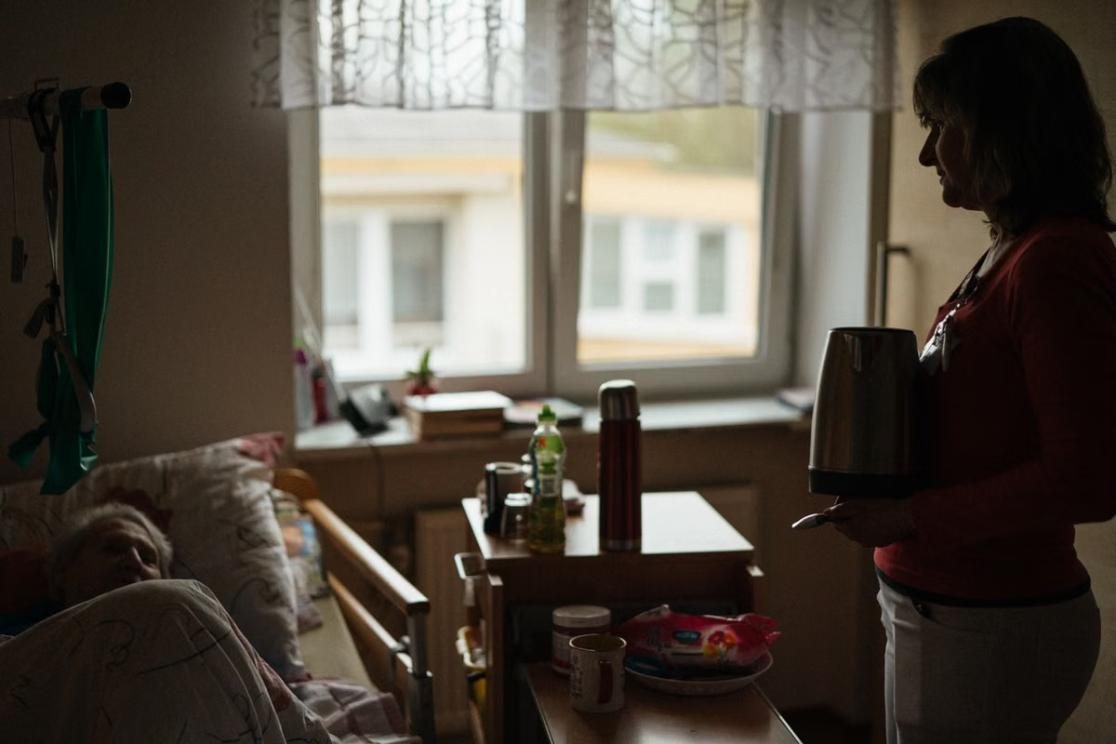 A caregiver preparing a warm drink for a client at home